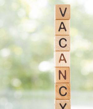 vacancy word is made of wooden blocks lying on the table, concept, green background